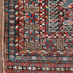 an antique qashqai rug with a dark blue field and intricate colourful details