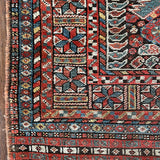 an antique qashqai rug with a dark blue field and intricate colourful details
