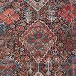 an antique qashqai rug with a dark blue field and intricate colourful details