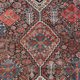 an antique qashqai rug with a dark blue field and intricate colourful details