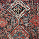 an antique qashqai rug with a dark blue field and intricate colourful details
