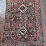 an antique qashqai rug with a dark blue field and intricate colourful details