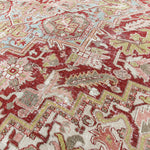 Close-up of a patterned rug with red, beige, and green colors.