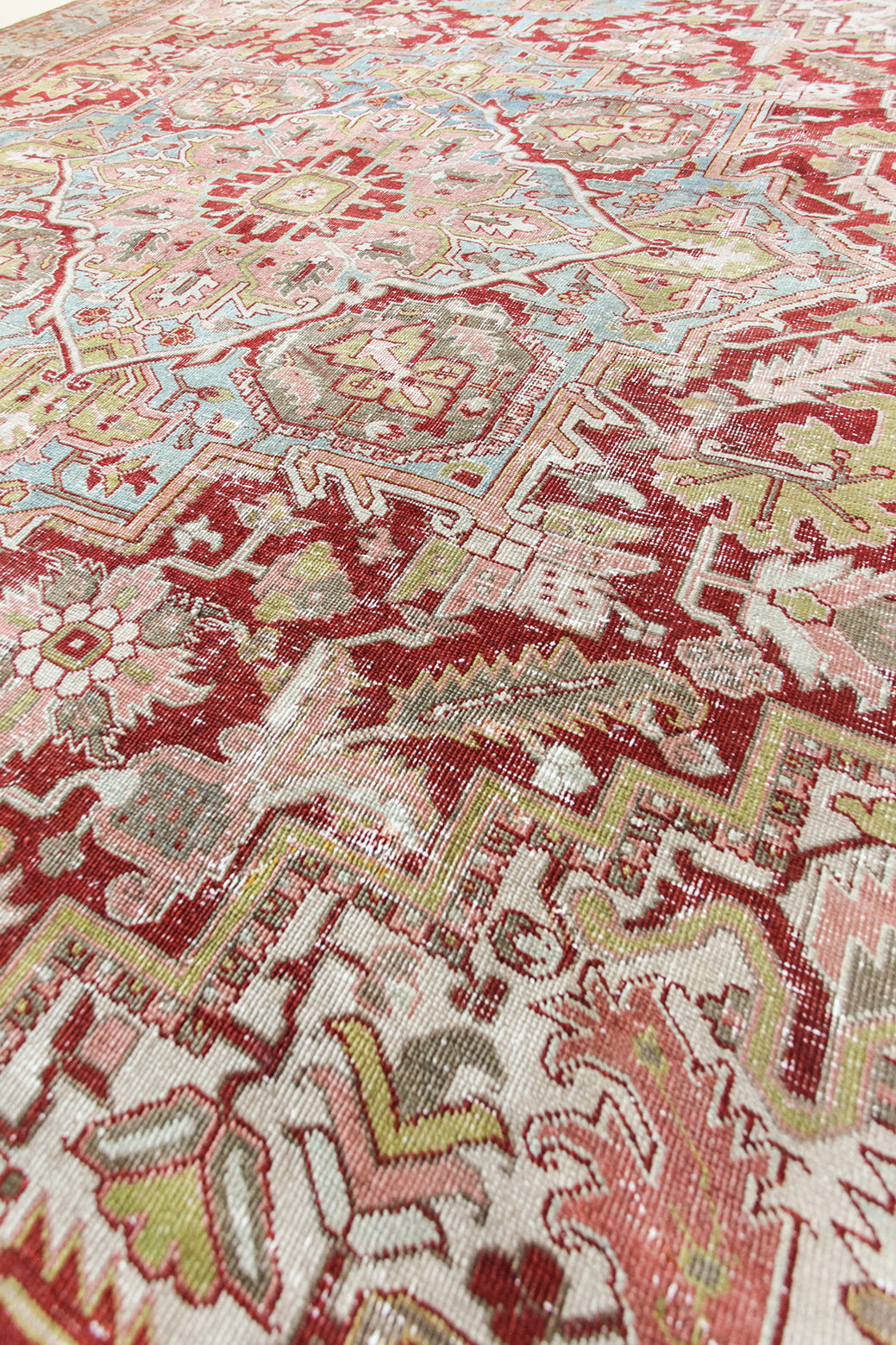 Close-up of a patterned rug with red, beige, and green colors.