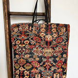 an overnight tote bag made with antique rug and suede