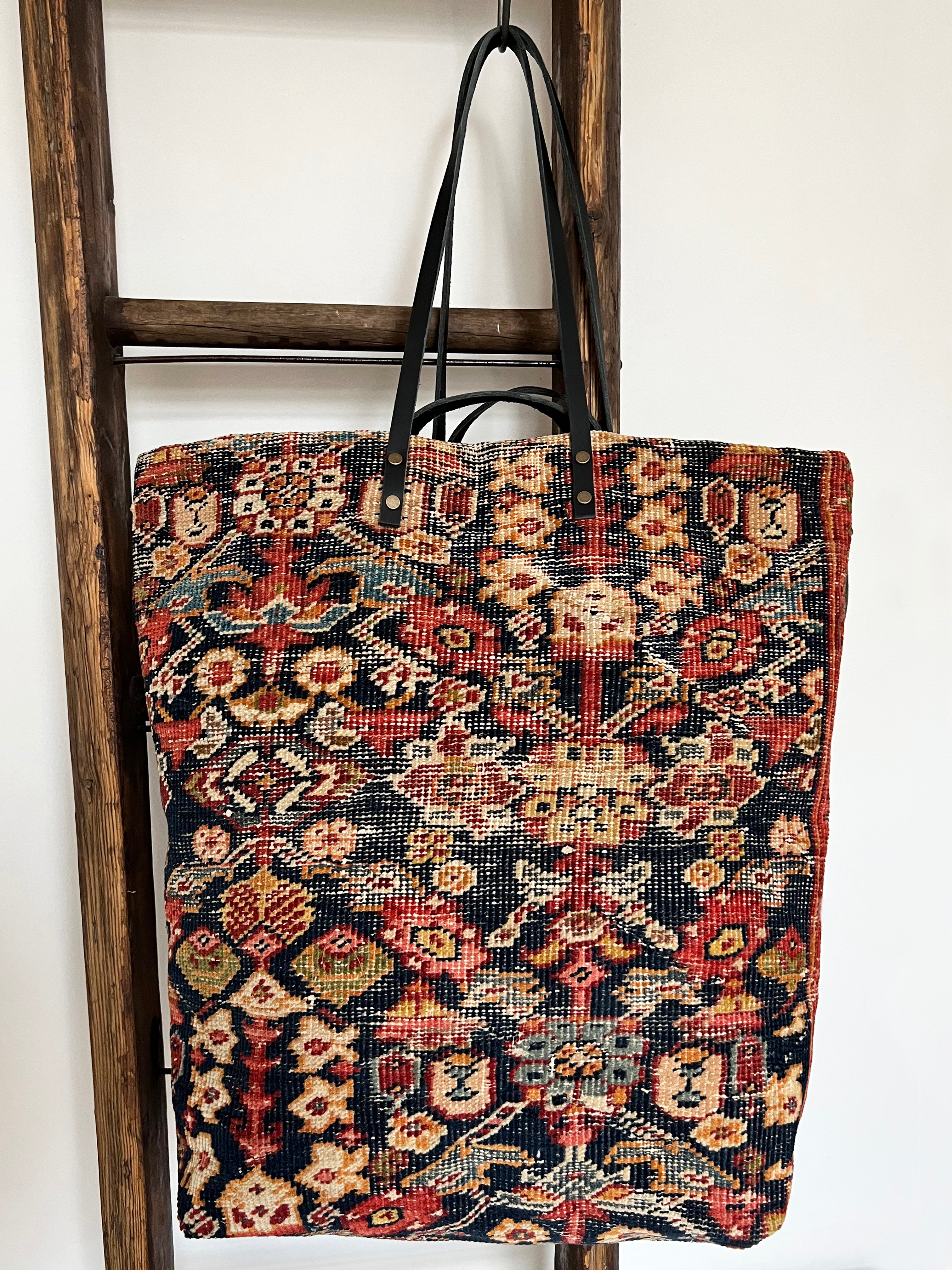 an overnight tote bag made with antique rug and suede