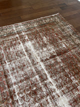 an antique persian rug with a teal border, dark red field and fine paisley pattern