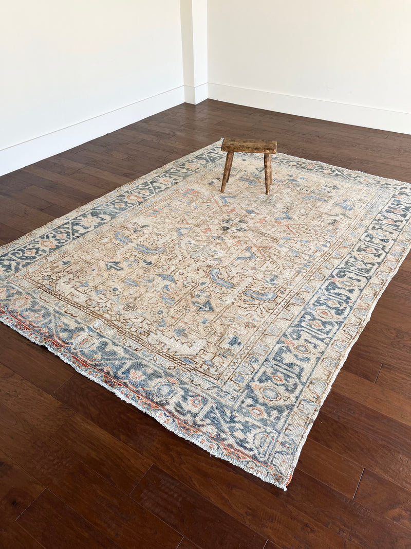 an antique malayer rug with a neutral field and baby blue and coral accents