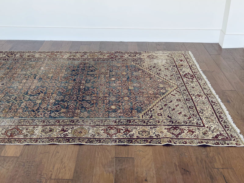 an antique Malayer rug with blue palette and cream trellis details