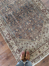 an antique Malayer rug with blue palette and cream floral details