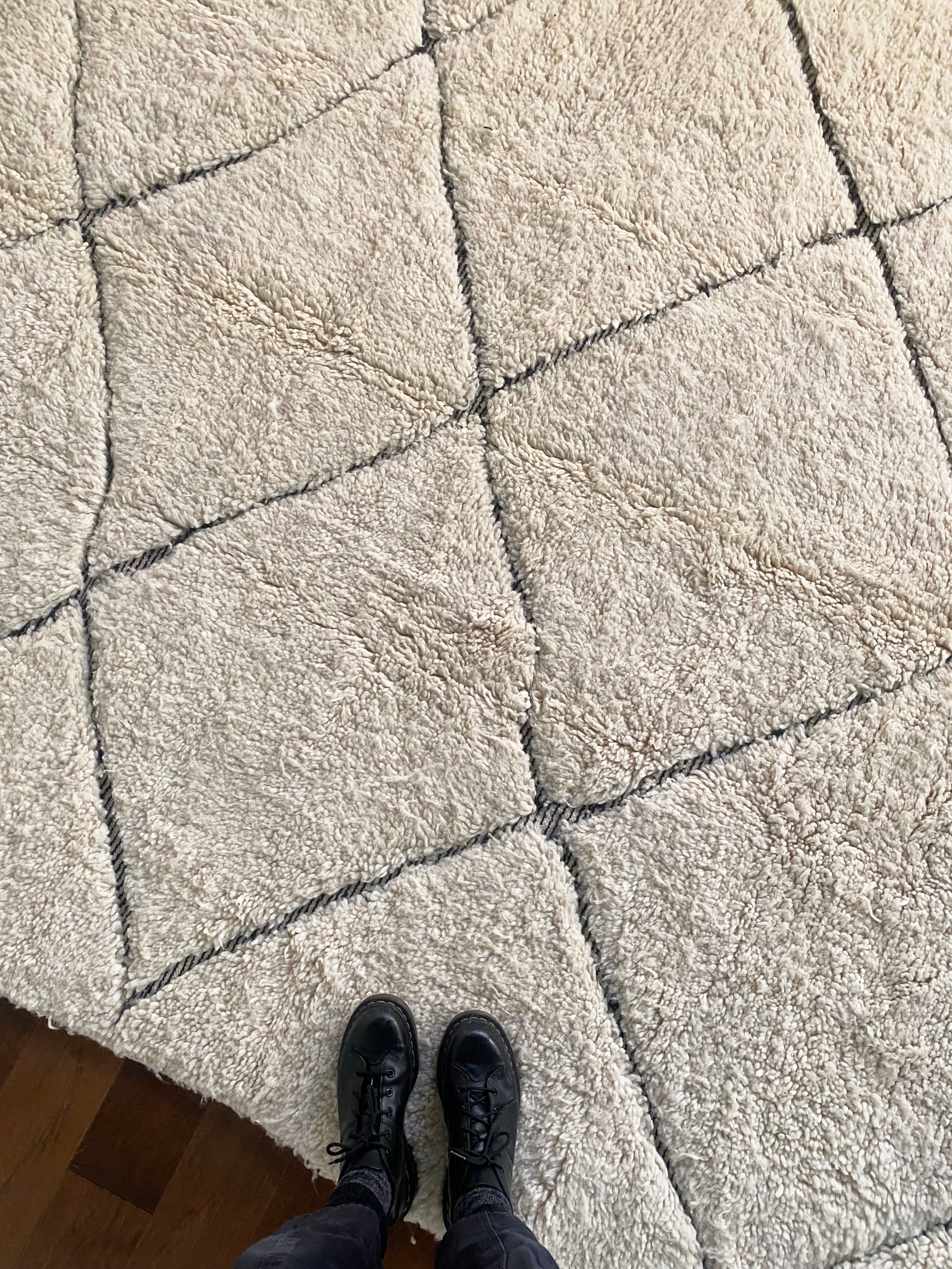 a large vintage berber rug with undyed wool and a large black diamond pattern