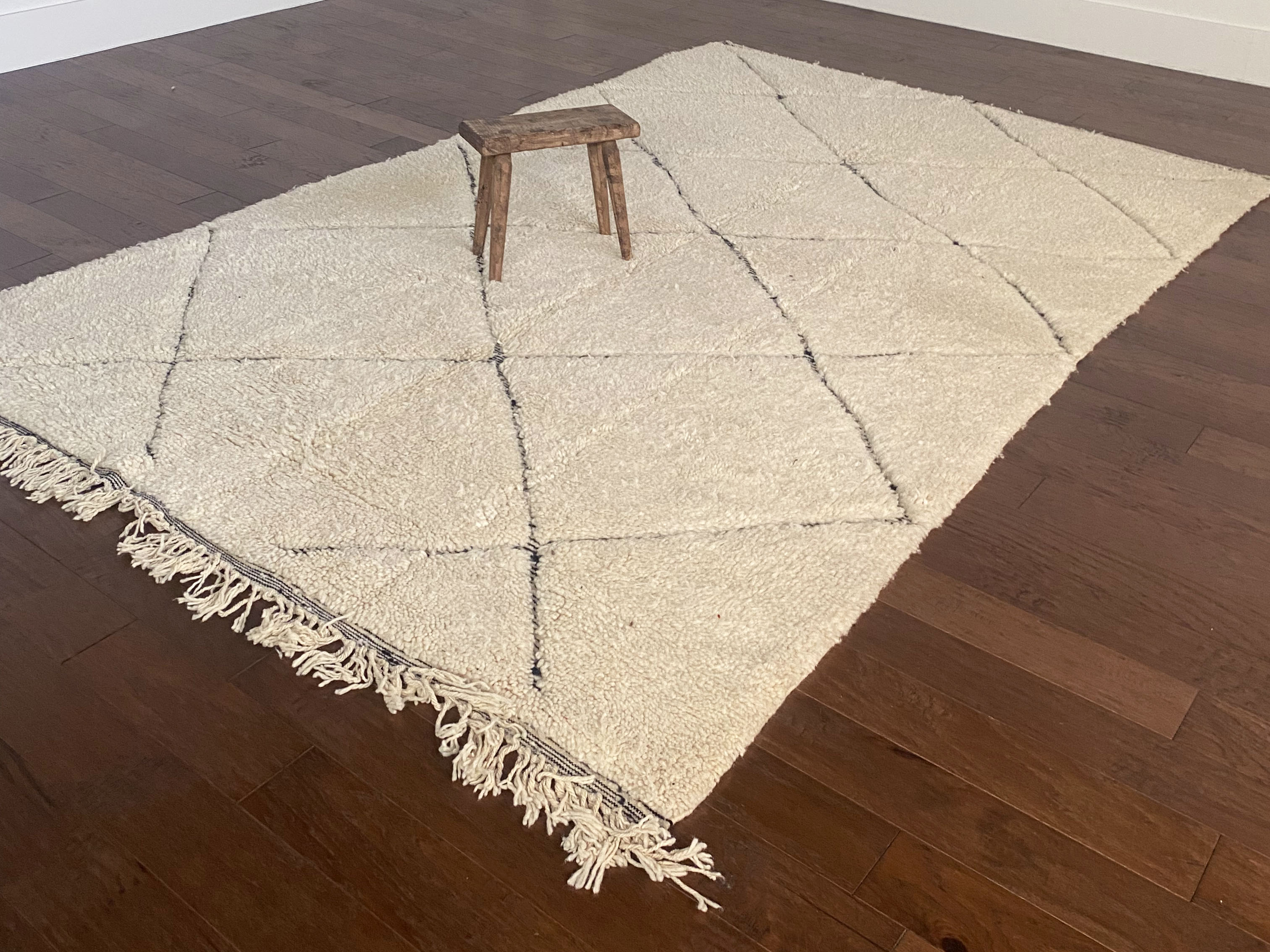 a large vintage berber rug with undyed wool and a large black diamond pattern