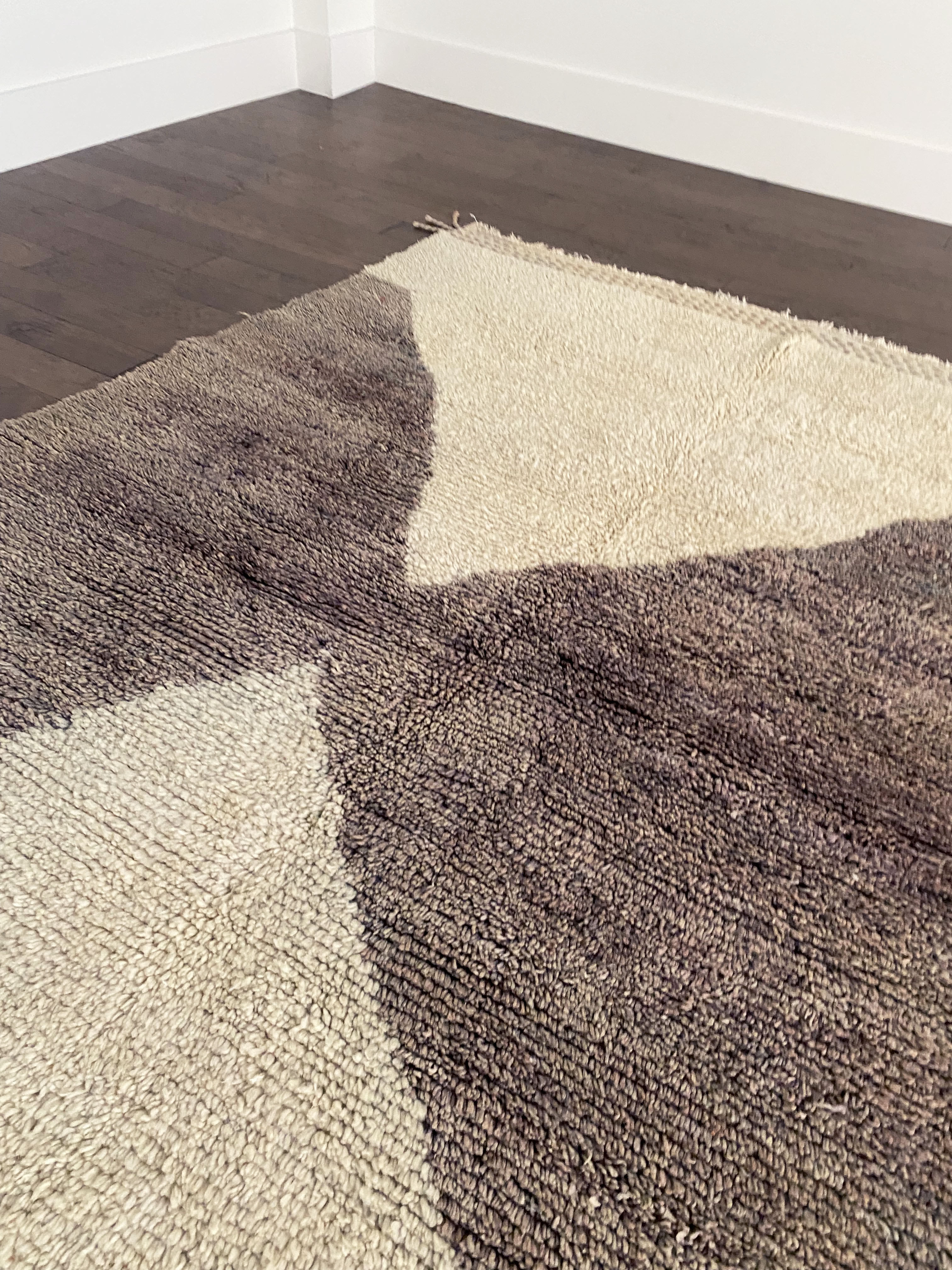 a vintage berber rug with two large taupe diamonds on a cream wool field