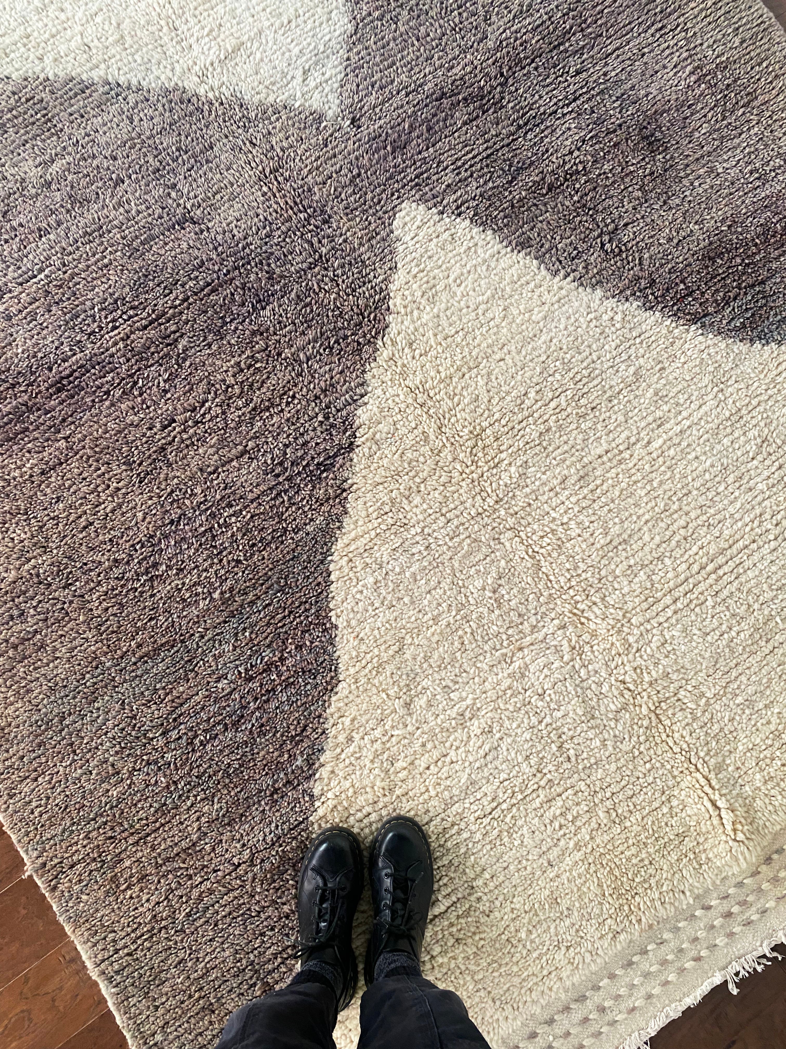 a vintage berber rug with two large taupe diamonds on a cream wool field