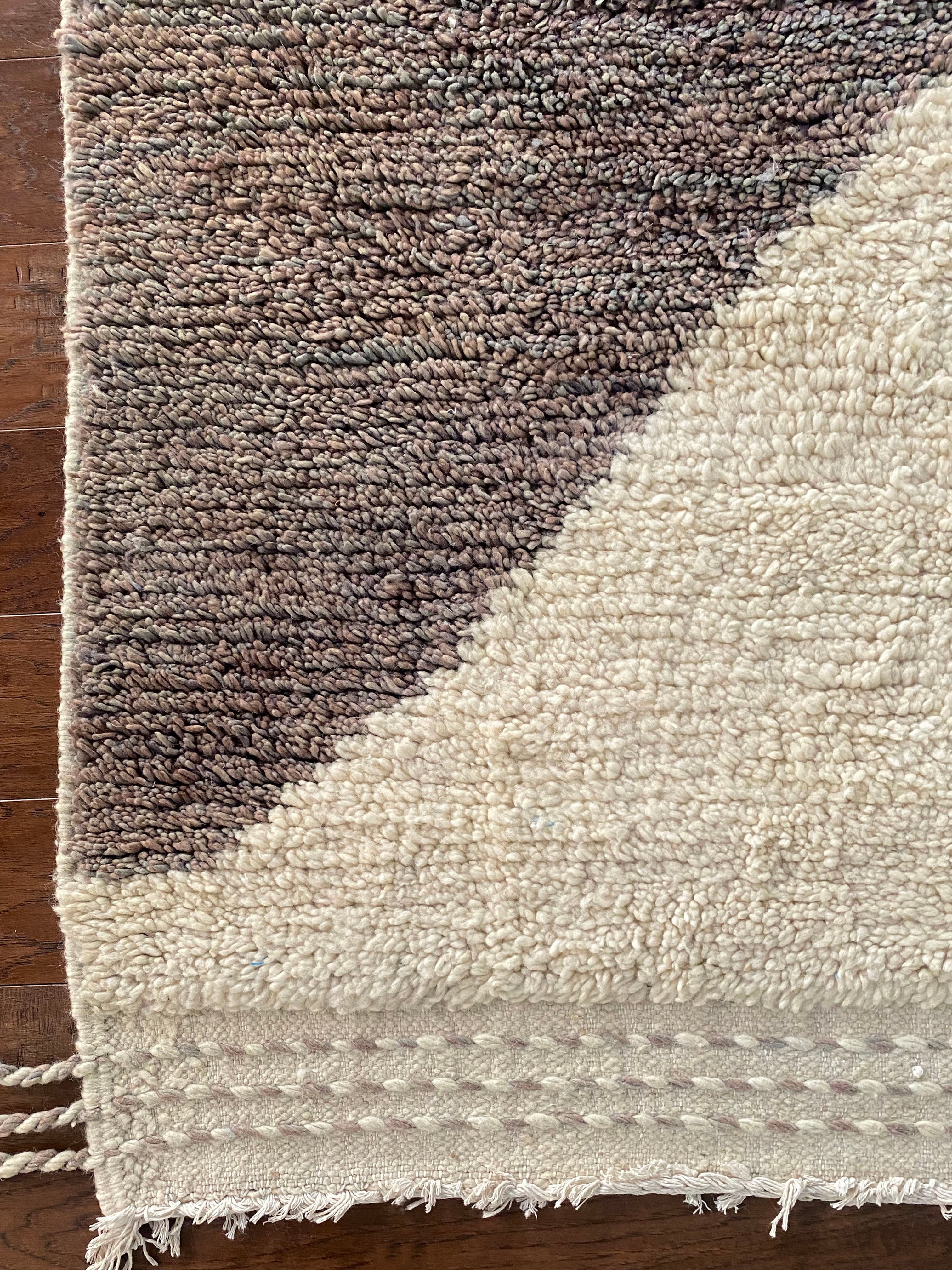 a vintage berber rug with two large taupe diamonds on a cream wool field