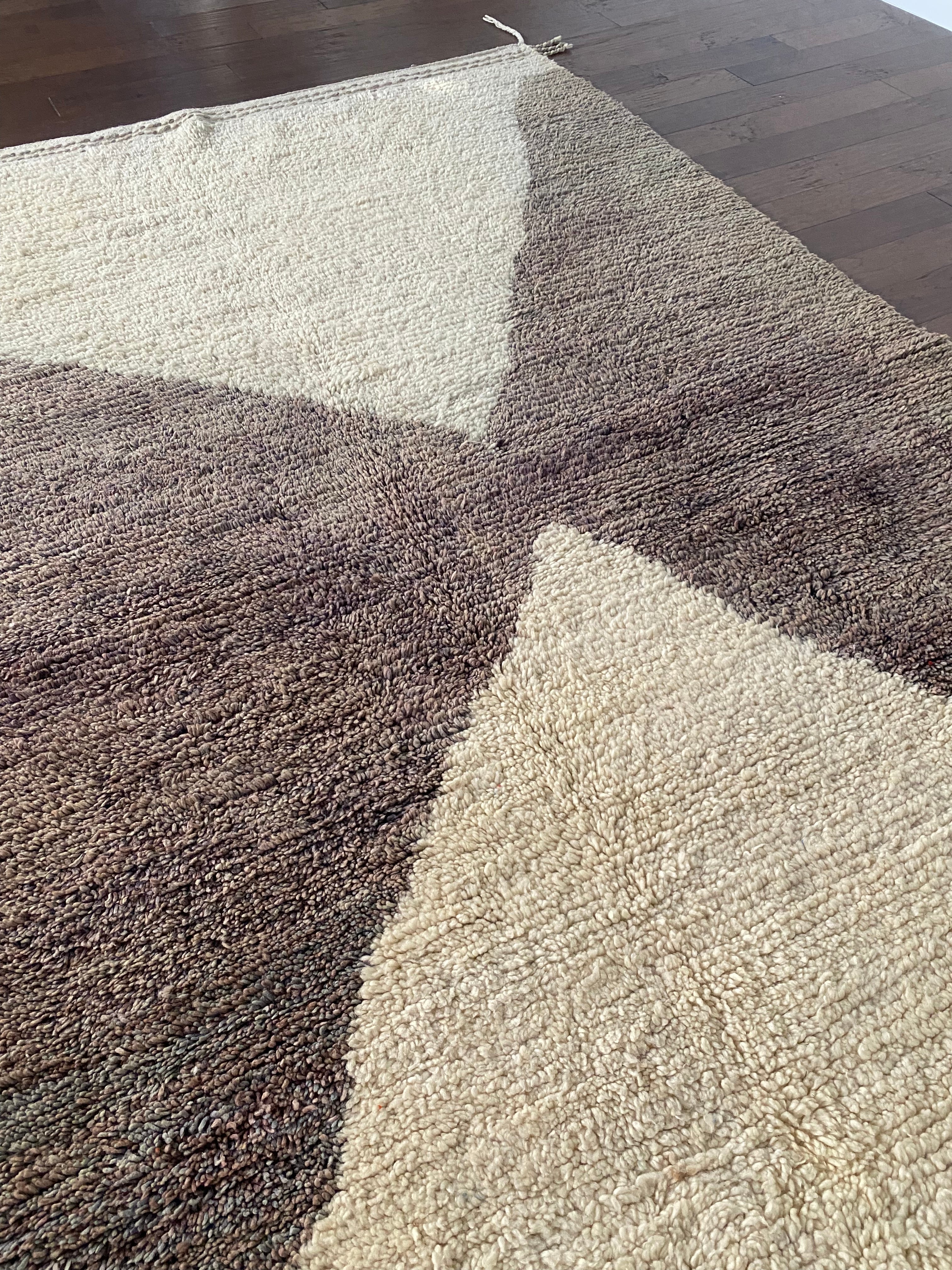 a vintage berber rug with two large taupe diamonds on a cream wool field