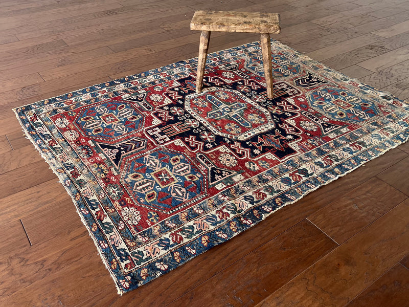 an antique caucasian shirwan rug with teal border, 4 blue corner medallions and a red field