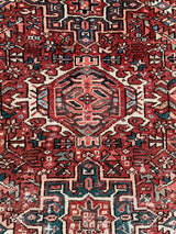 a vintage heriz karajah rug with pink and coral accents and two green medallions
